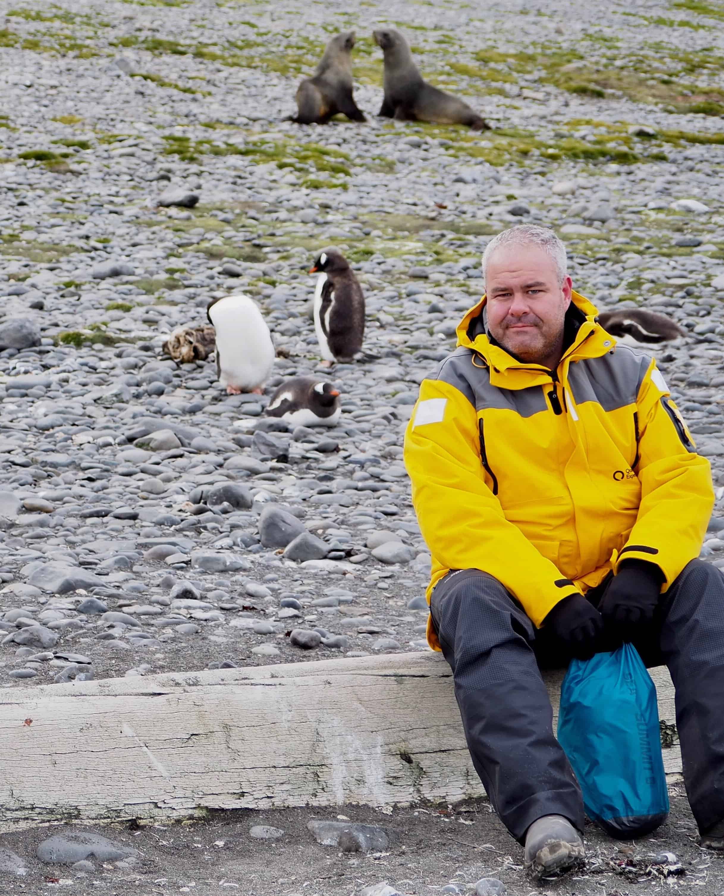 Sitting down with some penguins and seals at Elephant Point, Antarctica